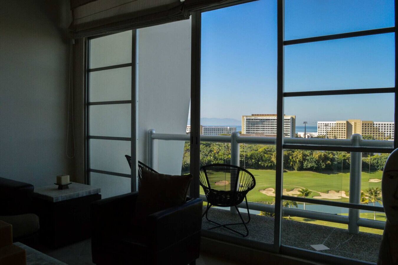 Un balcon avec vue sur un terrain de golf et des immeubles.