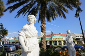 A statue of a woman holding a book, with a palm tree and a building labeled "Alvin's Island" in the background. - 1/1 Waterview Condo, Pool, Private Beach Access (Longboat Key)