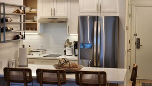 A modern kitchen with white cabinetry, stainless steel appliances, and pendant lighting. - 1/1 Waterview Condo, Pool, Private Beach Access (Longboat Key)