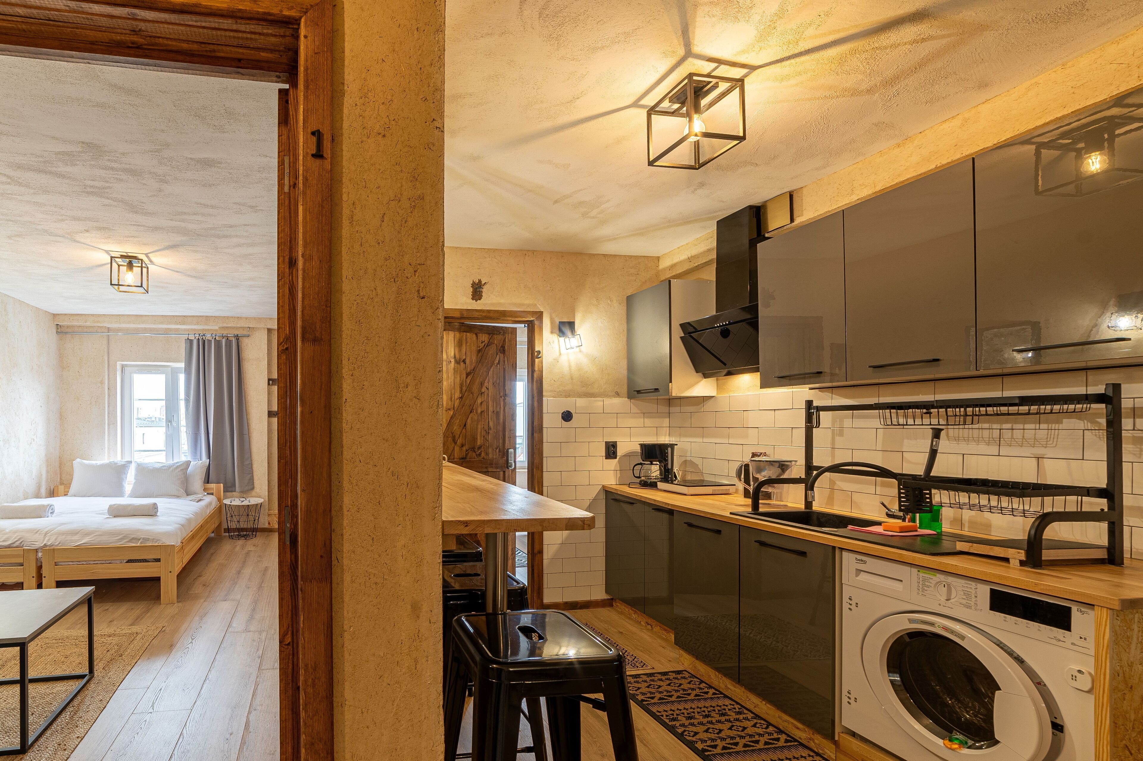 A compact apartment with a kitchen, a dining area, and a bedroom.