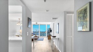 Un intérieur moderne avec vue sur la mer, comprenant une cuisine, un coin repas et un espace de vie agrémenté d’une grande fenêtre.