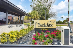 A sign for 'Beachplace' with a number '1045-1145' and a building with a covered area.