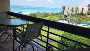A balcony with a view of the ocean, a pool area, and a building in the background. - 2/2 Condo BEACH VIEW, Pool, Fitness, Tennis (Longboat Key)
