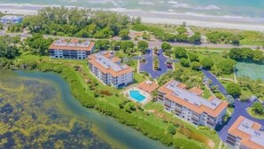 A resort with multiple buildings, a swimming pool, and a beach view. - 2/2 Bay Front Condo, Pool, Private Beach Access (Longboat Key)