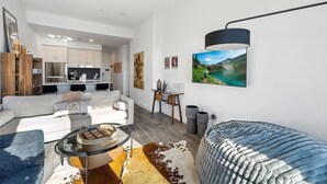 A modern living room with a sofa, coffee table, and a painting of a landscape. - Deer Valley East I Walk to Jordanelle Gondola I Hot Tub I Arcade (Park City)