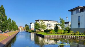 Un canal flanqueado por edificios modernos a un lado y una torre al otro.