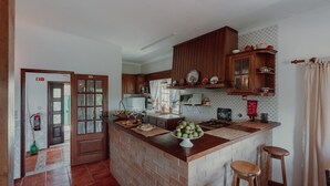 Une cuisine avec des meubles en bois, un îlot central en briques et un four à micro-ondes.
