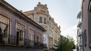 A historic building with ornate architectural details, including a clock and decorative tiles.