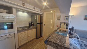 A compact kitchen with white appliances, a coffee maker, and a refrigerator. - Résidence La Belle Poule 1172 (Sainte-Maxime)
