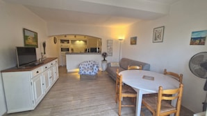 A compact living space with a kitchenette, a dining area with a table and chairs, a sofa, and a TV on a cabinet. - Résidence La Belle Poule 1172 (Sainte-Maxime)
