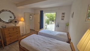 A bedroom with two single beds, a wooden dresser, a mirror, and a lamp. - Résidence La Belle Poule 1172 (Sainte-Maxime)