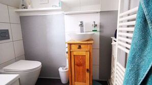 A compact bathroom with a toilet, sink, and cabinet.