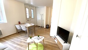 Un espai vital compacte amb zona de menjador, televisió i un petit seient.