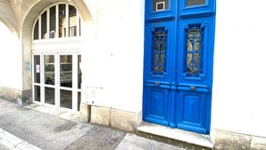 Un edifici amb façana blanca i porta blava amb treballs metàl·lics ornamentals.