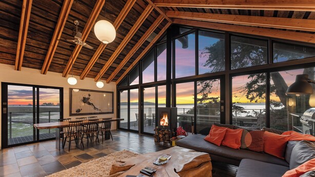 Un amplio salón con chimenea, ventanas grandes y una acogedora zona de estar.