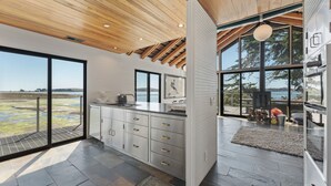 Una cocina moderna con ventanas amplias, techo de madera y vistas al exterior.