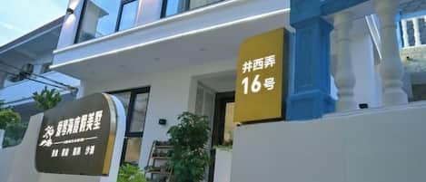 A modern building with a balcony, a sign indicating room number 16, and a sign with Chinese characters.