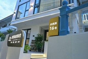 A modern building with a balcony, a sign indicating room number 16, and a sign with Chinese characters. - Aiqinhai Hotel (Shengsi)