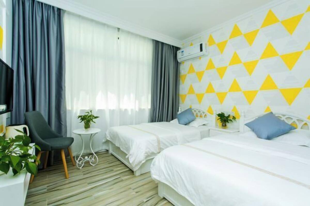 Una habitación de hotel con dos camas, un escritorio, una silla y un televisor.