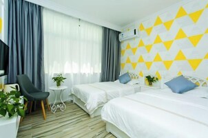 Una habitación de hotel con dos camas, un escritorio, una silla y un televisor.