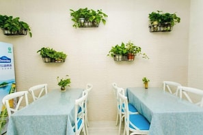 A conference room with a whiteboard, a Cheerday poster, and potted plants on the walls.