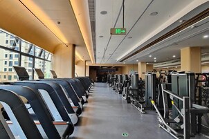 Un gimnasio con equipo de ejercicio y cintas de correr.