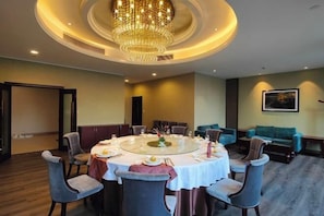 A dining area with a round table, chairs, and a chandelier. - Oriental Hotel (Kaihua Linhu Road) (Kaihua)