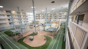 A multi-level indoor complex with balconies, a central courtyard, and a pool area. - Island Sunrise HHI Condo (Hilton Head Island)
