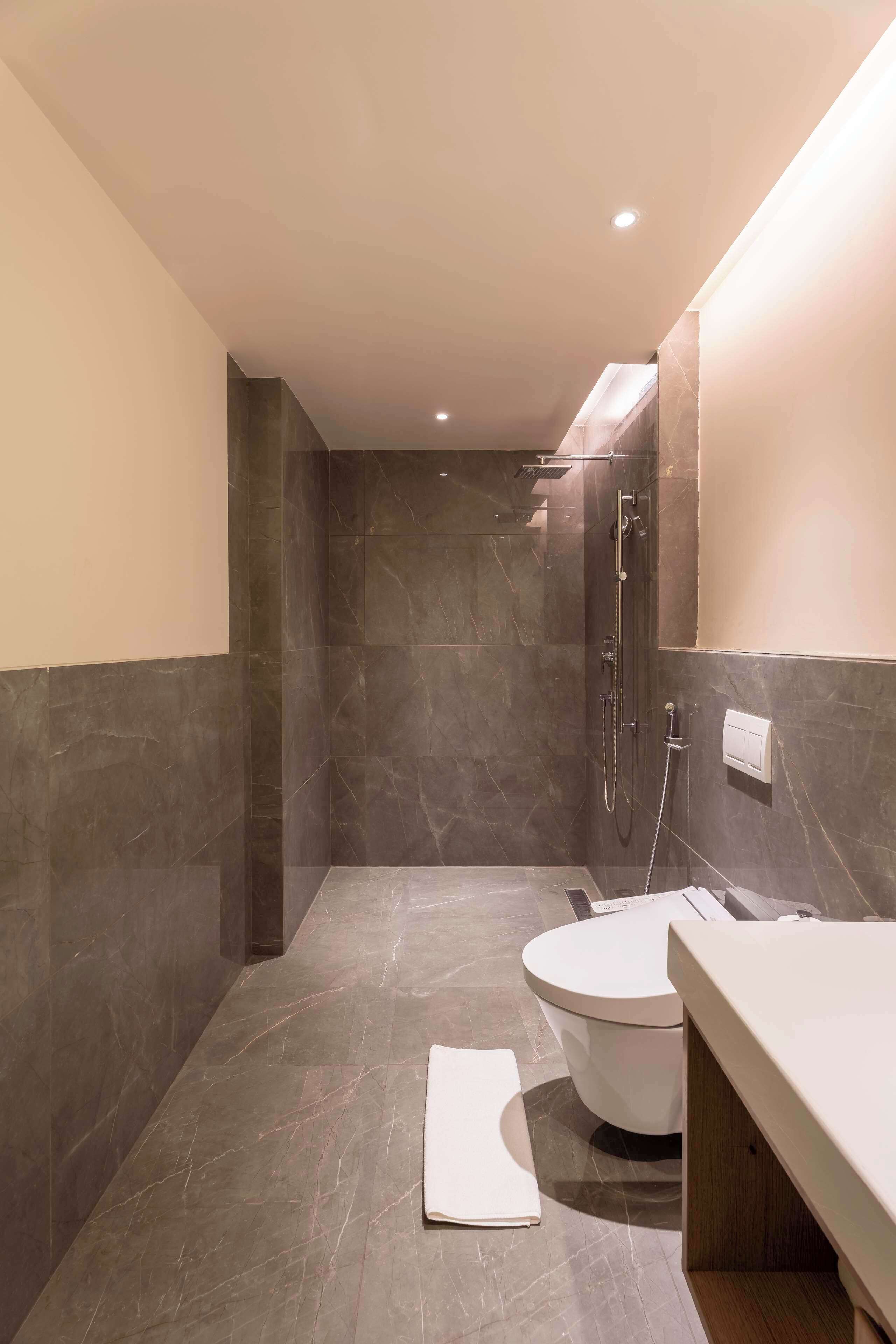 A modern bathroom with a shower, toilet, and vanity.