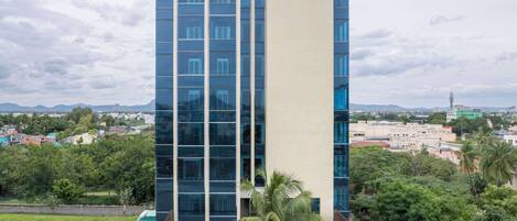 Un hotel moderno con un cartel llamativo de 'Park Inn', ventanas amplias y vistas de la ciudad circundante.