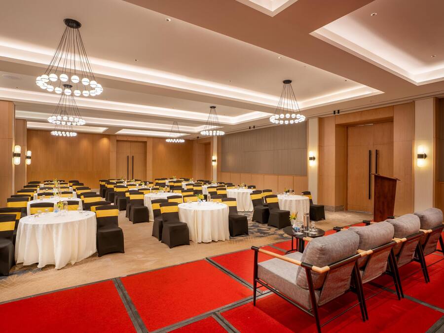 Un salón de conferencias con varias mesas, sillas y un atril.