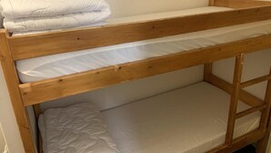 Ein Etagenbett mit zwei Schlafstellen, jeweils mit Matratze und Kissen.