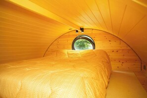A cozy, circular room with wooden walls and a single window. - Woodland Lodge, Aberporth (Brongest)