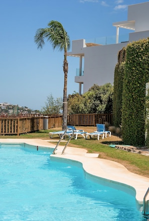A swimming pool with lounge chairs and a palm tree. - Overlook Apartment in Mijas - Ref 254 (Mijas)