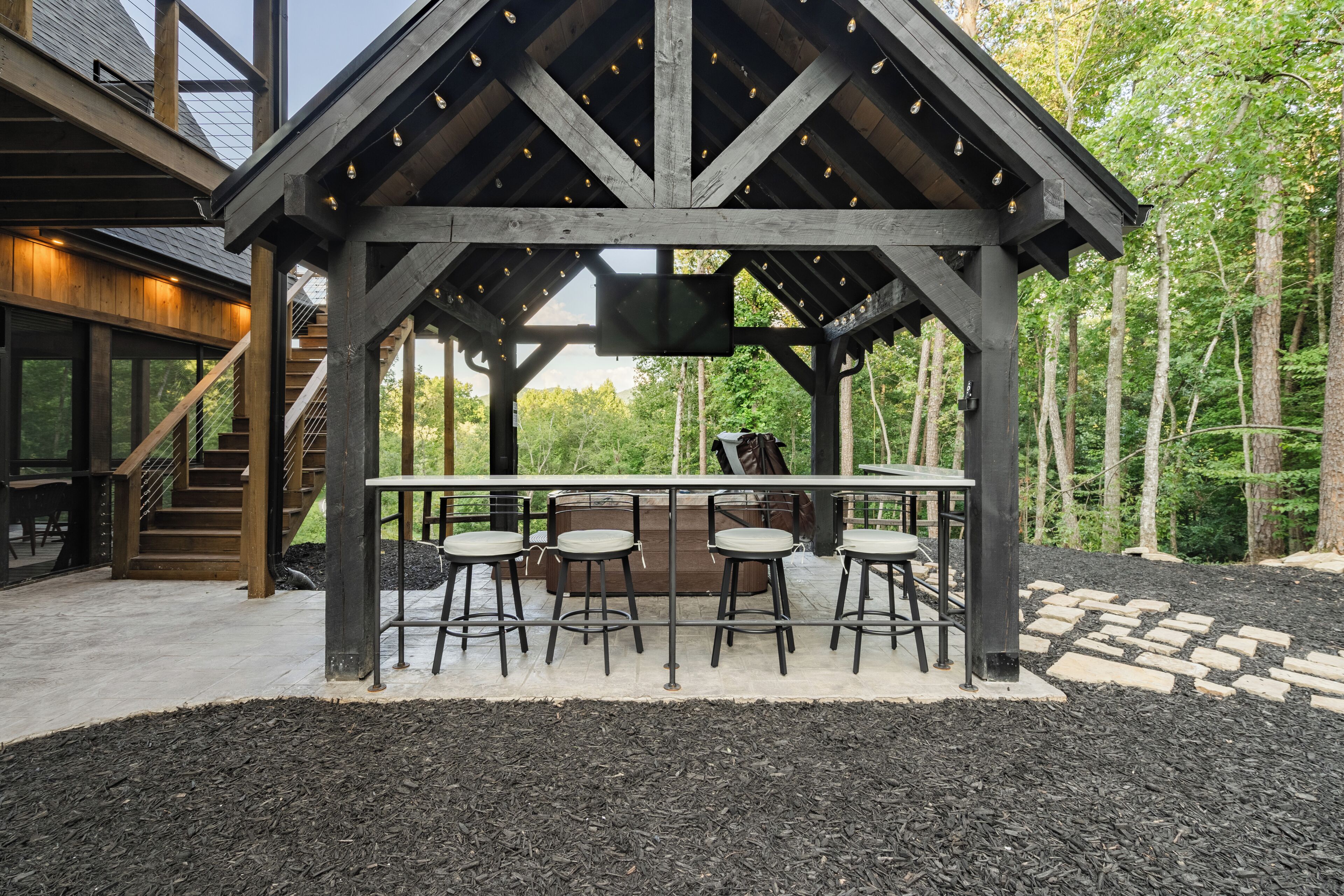 Ein hölzerner Pavillon mit Barbereich und Sitzgelegenheiten.