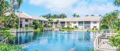 A resort with multiple buildings, a central water feature, and lush greenery.