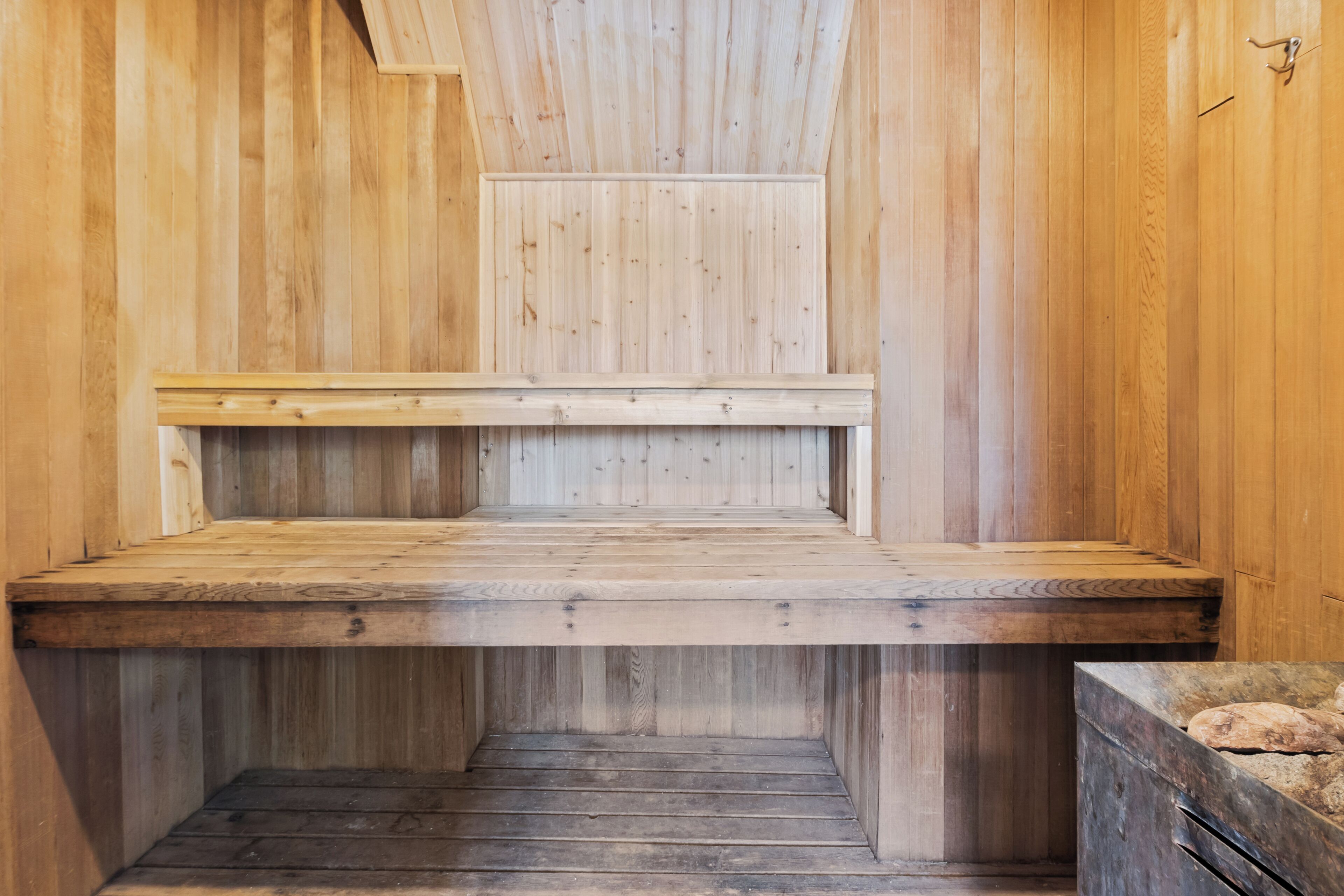 A sauna room with wooden walls and benches.