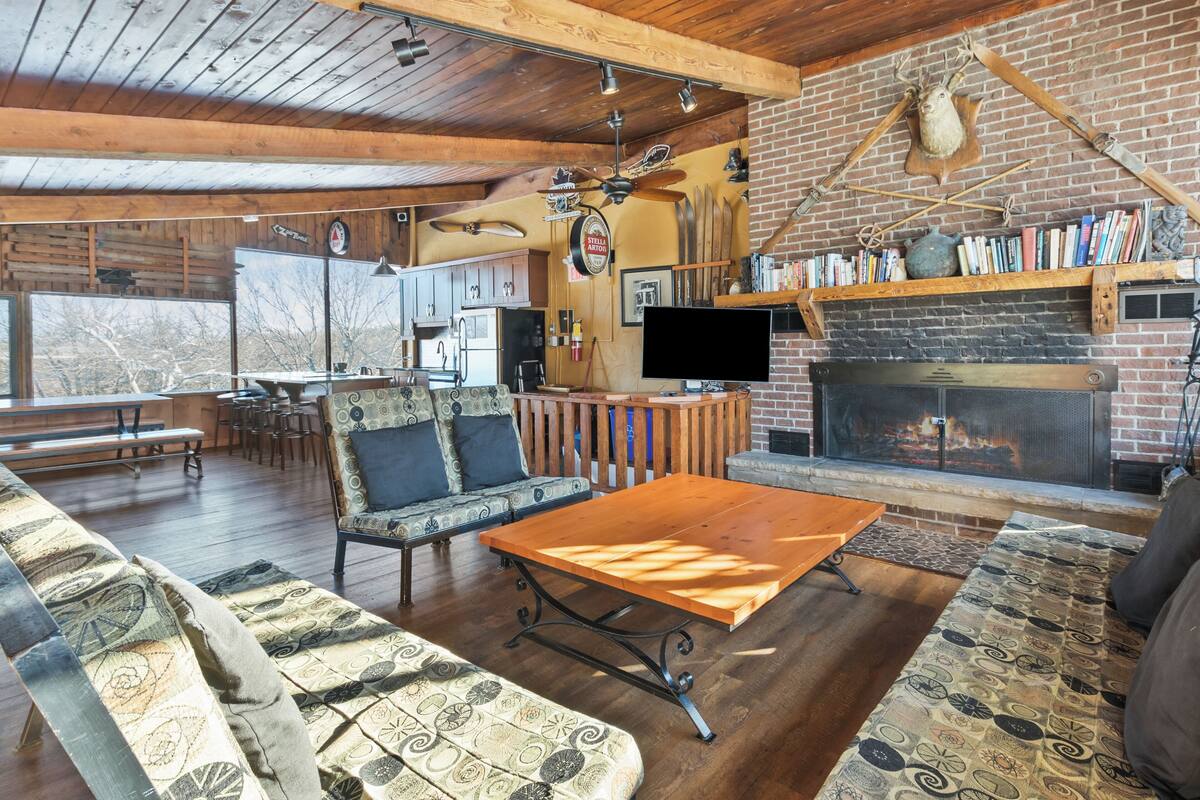 Una sala de estar acogedora con chimenea, muebles de madera y un televisor.