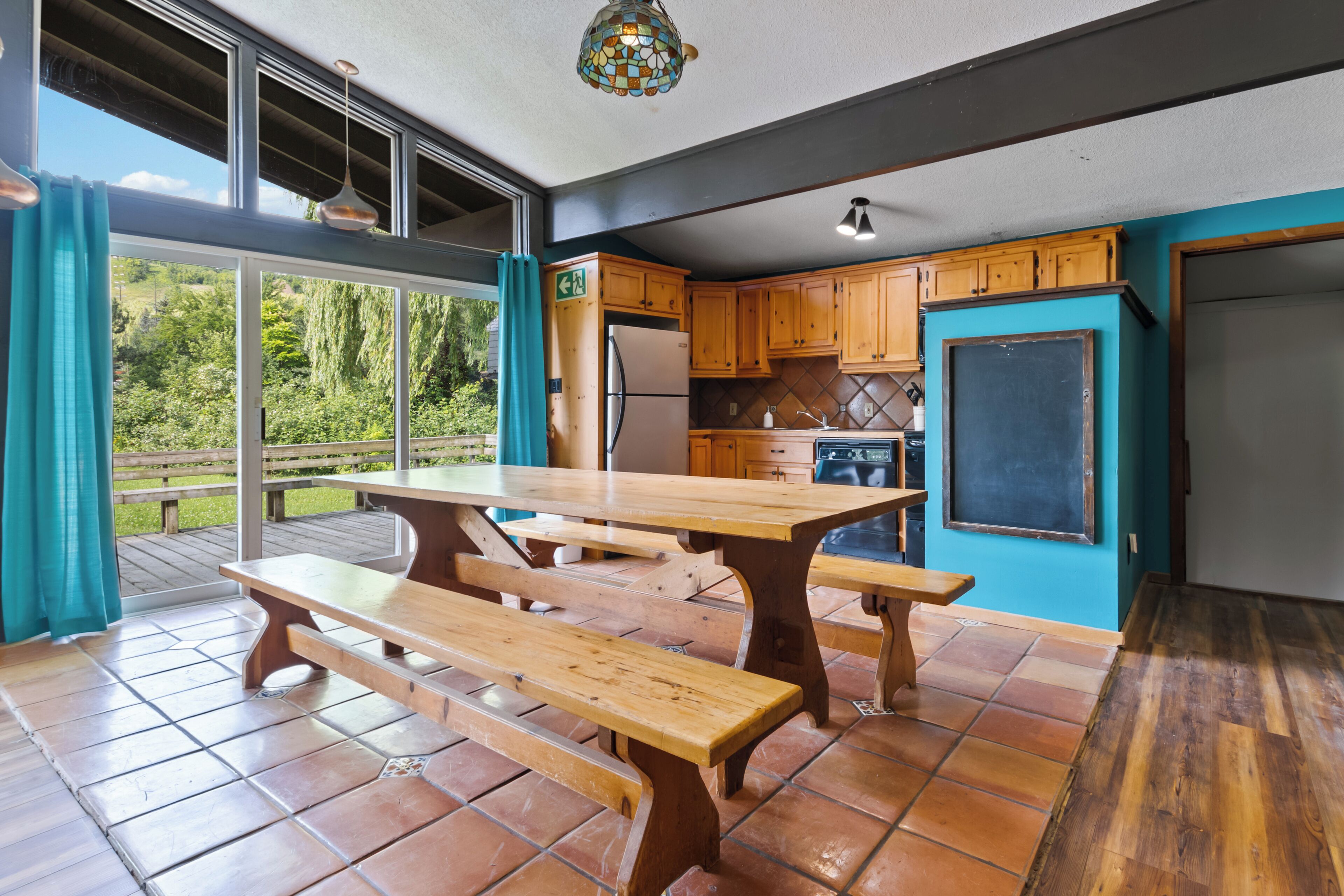Una cocina con armarios de madera, una mesa grande y vistas al exterior.