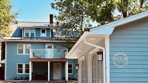 Ein zweistöckiges Gebäude mit Balkon, Garage und einem Schild, das es als Campingplatz kennzeichnet.