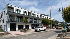 Un edificio moderno con fachada plana, ventanas amplias y exterior blanco.