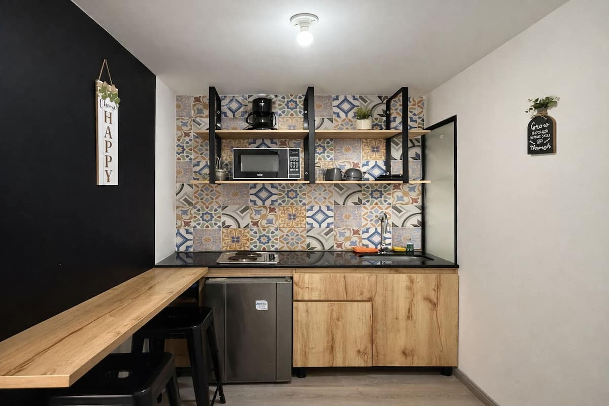 A compact kitchen with a microwave, coffee maker, and a small refrigerator.