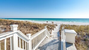 A wooden boardwalk leading to a beach with clear blue water and sandy shore. - Liahona: Private beach steps away, FREE golf cart, Heated pool, Gulf views (Miramar Beach)