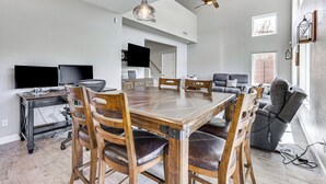 Un grand espace de vie comprenant une table à manger, des chaises, un canapé et un téléviseur.