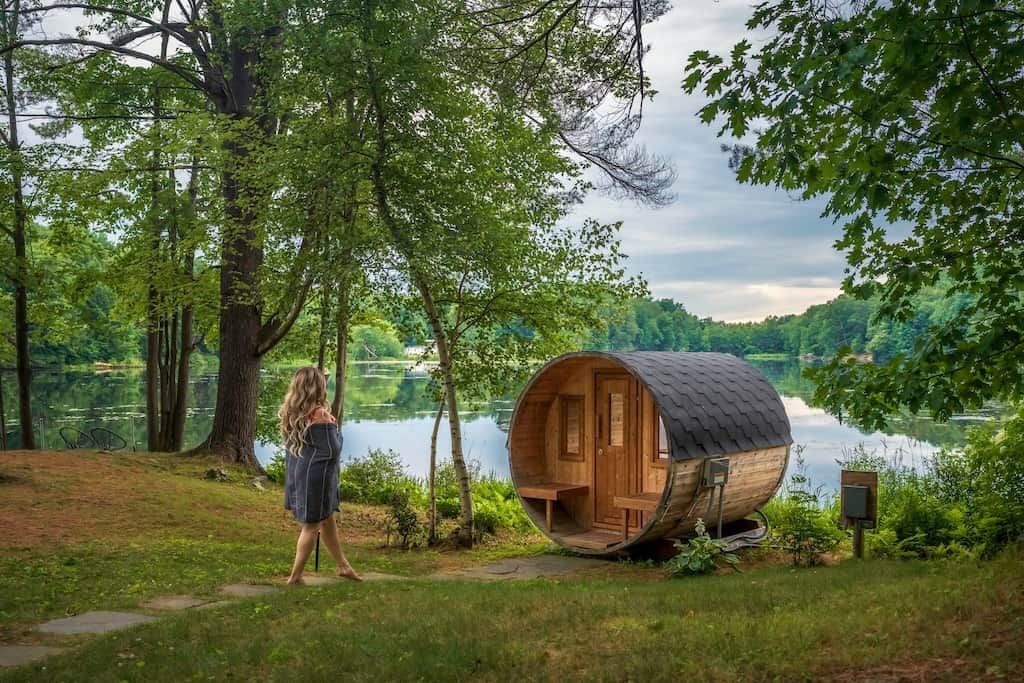 Une cabane en bois au bord d’un lac, entourée d’arbres.