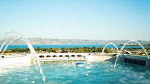 A pool with a view of a lake and mountains in the background.