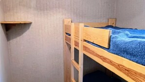 A bunk bed room with a small shelf and a wardrobe. - Cosy apartment with balcony (Le Monêtier-les-Bains)