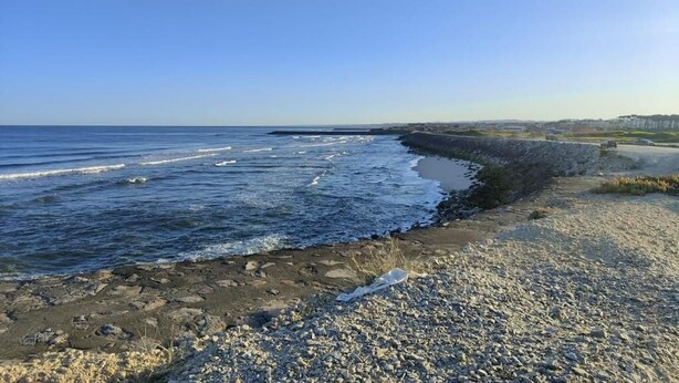 Una playa rocosa con olas rompiendo sobre la orilla.