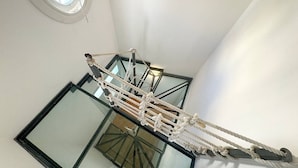Un ponte sospeso in una stanza con un'ampia finestra e un soffitto in vetro.