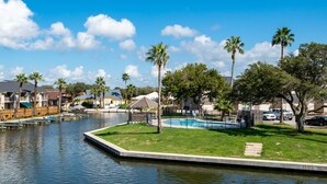 Un quartier résidentiel doté d’une piscine, de palmiers et de maisons.